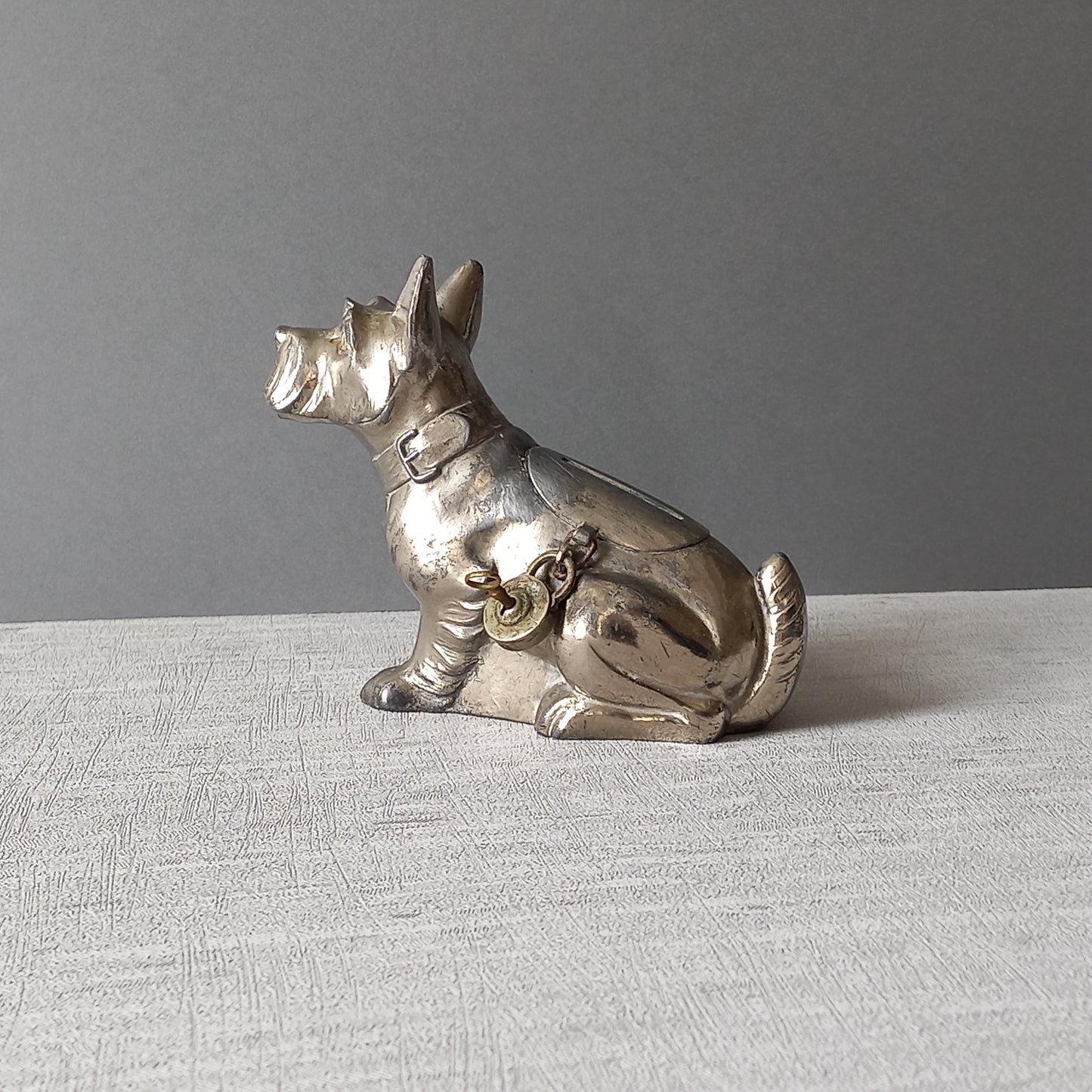 A fabulous French art deco metal terrier dog money box/coin storage box complete with a little padlock and key which still work.
This unique piece of history was purchased in south west France and we can only imagine who once owned it and what they might have saved their coins to buy.