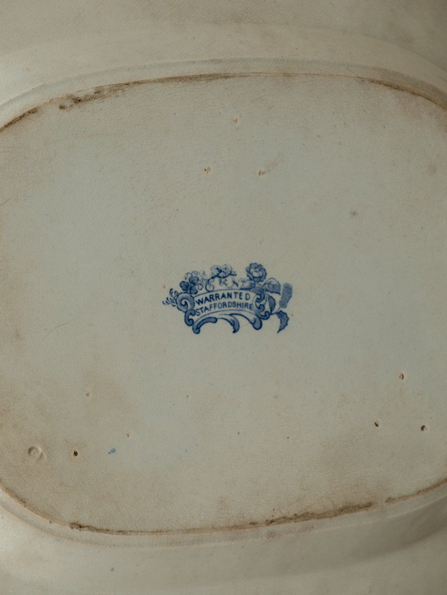 Close-up of a ceramic dish with a blue logo and text on a white background