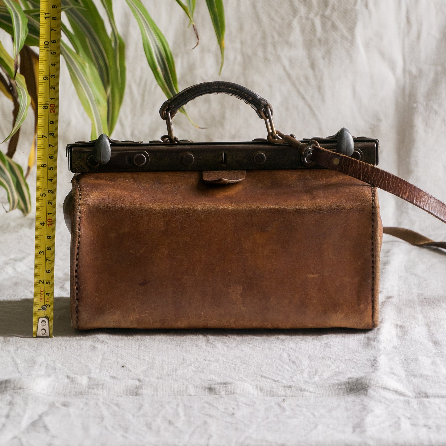 A French vintage leather shoulder/hand bag that's both practical and perfect as a prop or decorative piece in your interior, a beautifully aged piece with just enough patina of age to give it that authentic character. We have polished the distressed leather and thoroughly cleaned the bag both inside and out.