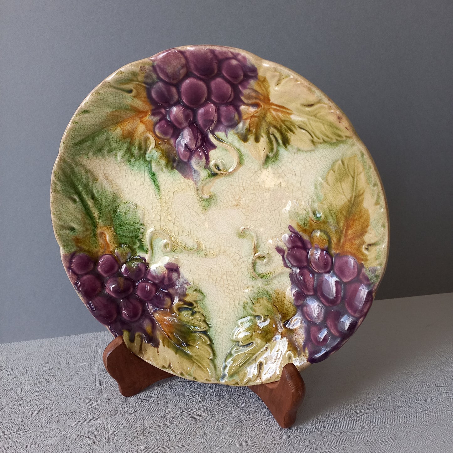 Small and beautiful French antique crazed majolica plate with a wonderful colour scheme depicting dark purple grapes and green foliage; this wonderful old plate will make an excellent addition to a collection or as a stand-alone display piece.