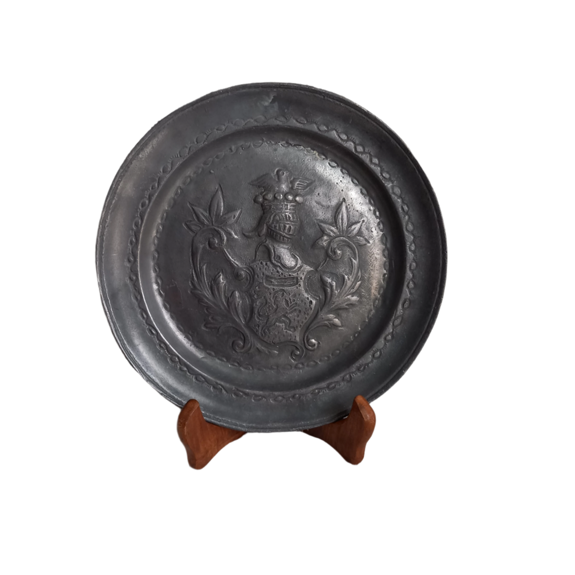 A small French vintage or antique embossed pewter plate with coat of arms depicting armor.