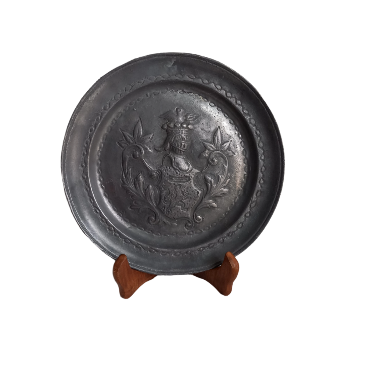 A small French vintage or antique embossed pewter plate with coat of arms depicting armor.