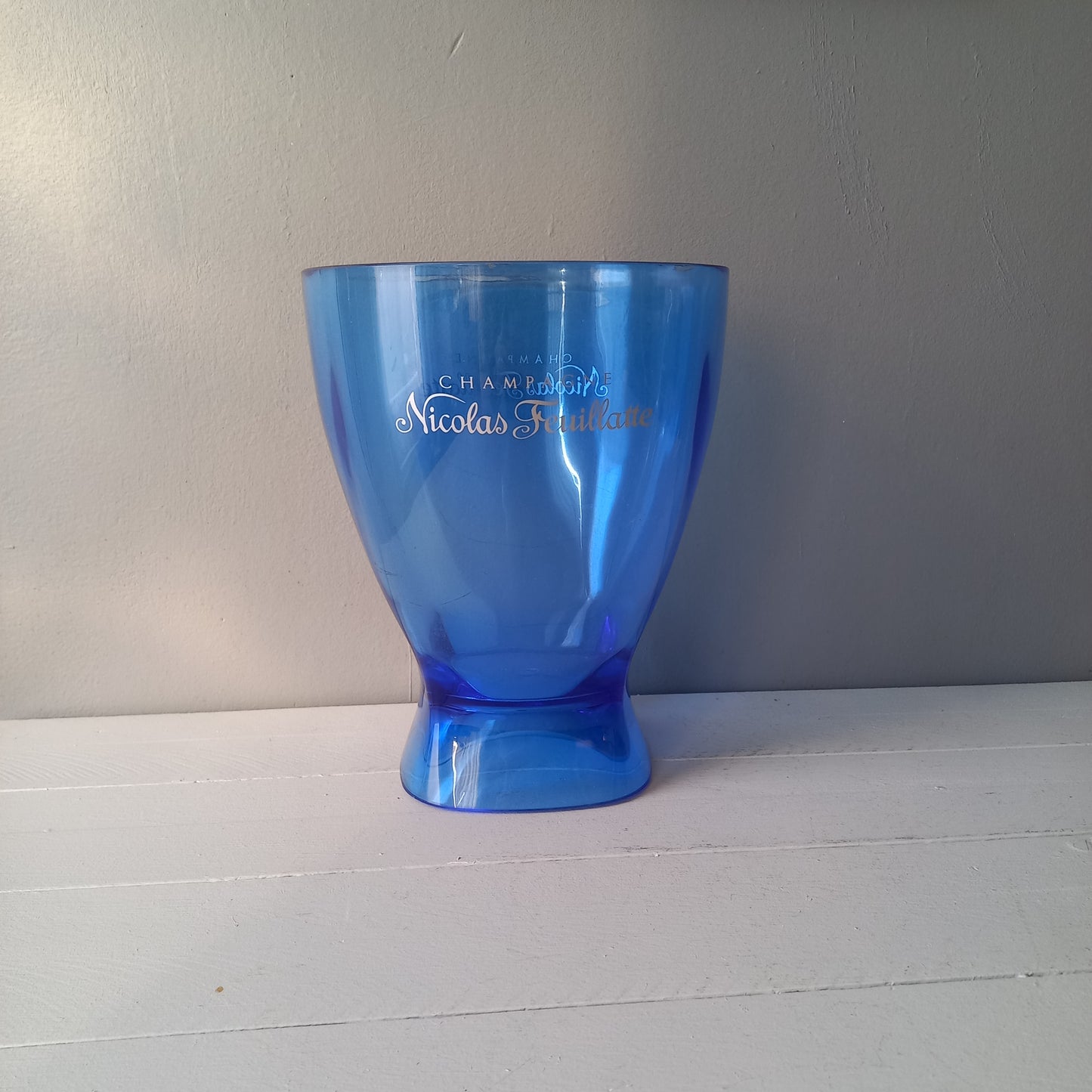 Vintage Nicolas Feuillatte transparent blue champagne bucket made from resin or hardened plastic. Being a vintage item there are of course some scuffs and scratches in the plastic.