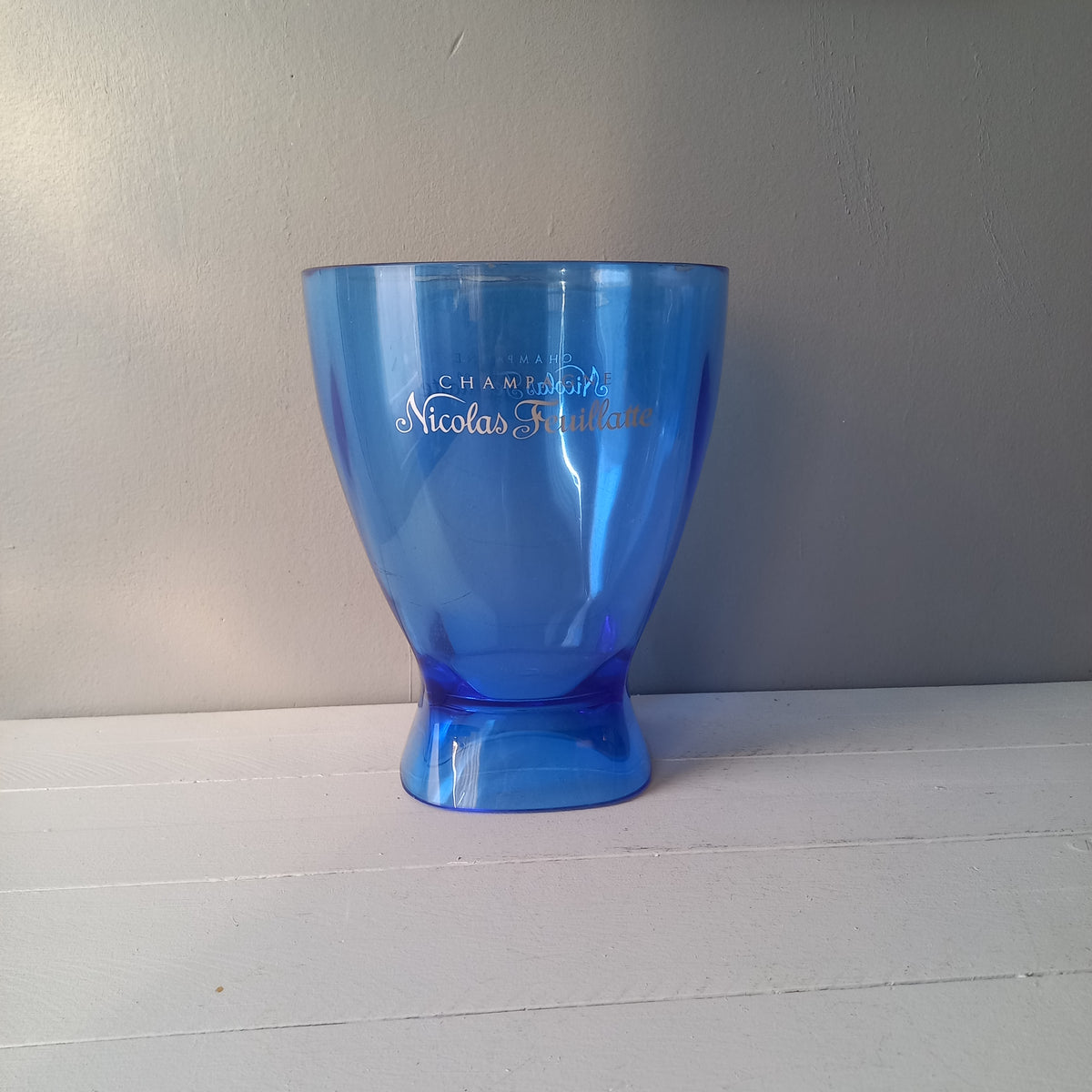 Vintage Nicolas Feuillatte transparent blue champagne bucket made from resin or hardened plastic. Being a vintage item there are of course some scuffs and scratches in the plastic.
