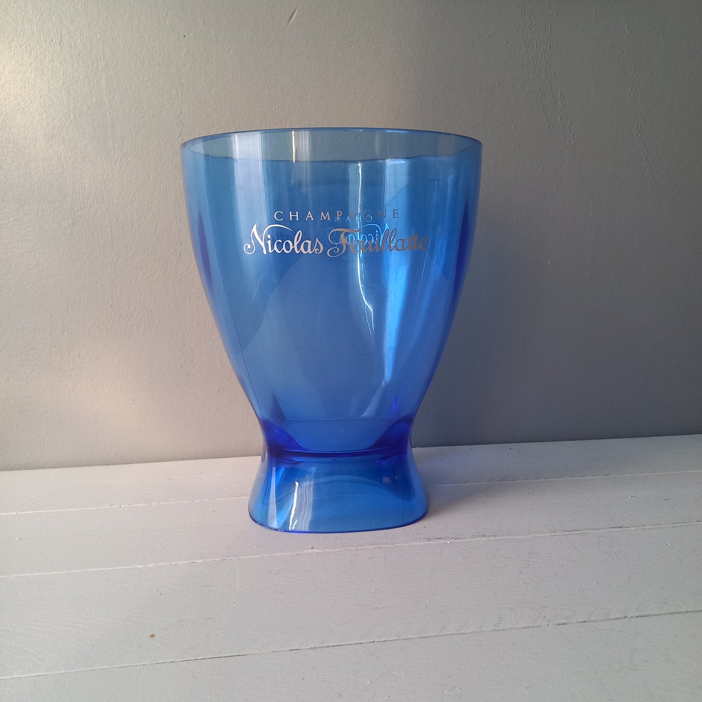 Vintage Nicolas Feuillatte transparent blue champagne bucket made from resin or hardened plastic. Being a vintage item there are of course some scuffs and scratches in the plastic.