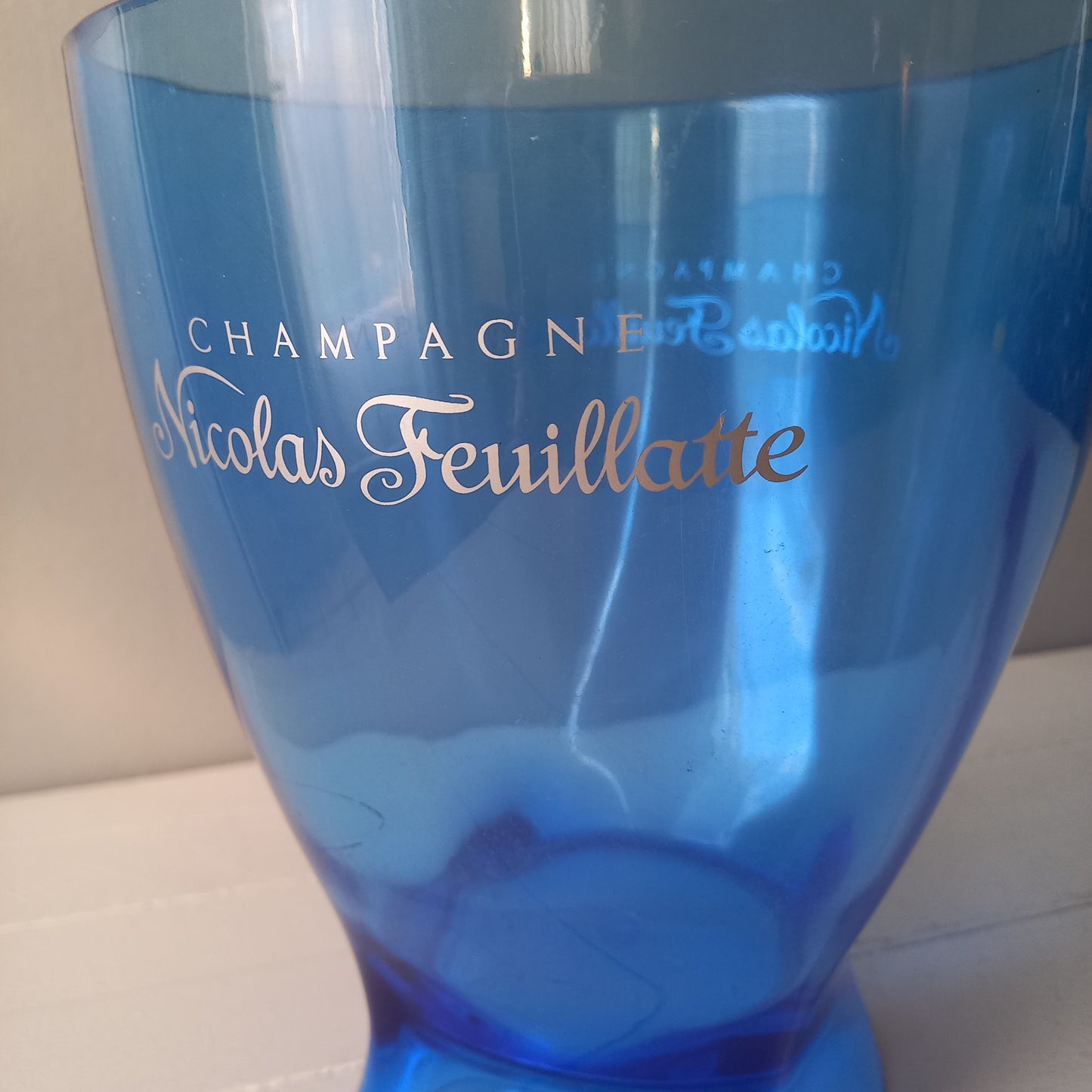 Vintage Nicolas Feuillatte transparent blue champagne bucket made from resin or hardened plastic. Being a vintage item there are of course some scuffs and scratches in the plastic.