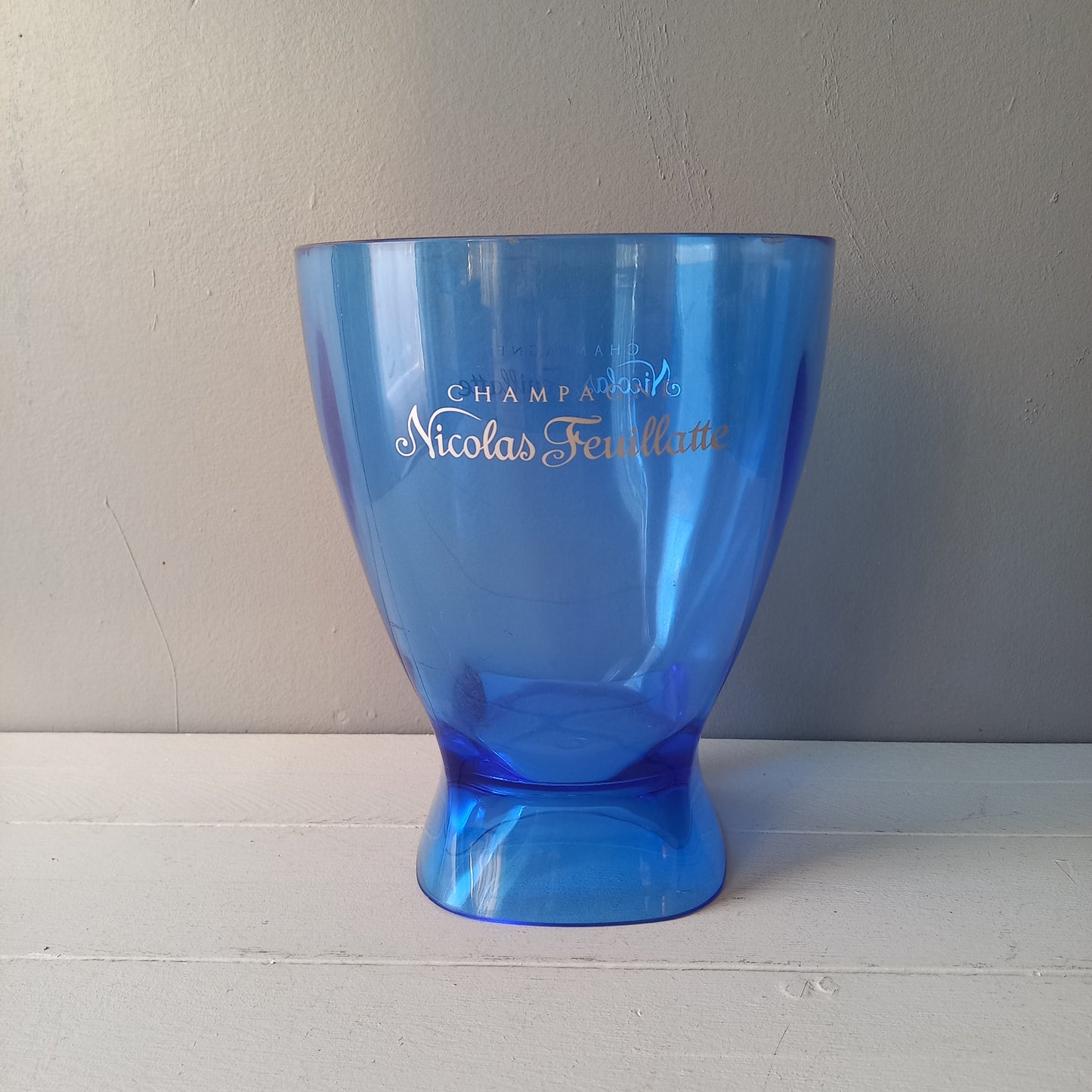 Vintage Nicolas Feuillatte transparent blue champagne bucket made from resin or hardened plastic. Being a vintage item there are of course some scuffs and scratches in the plastic.