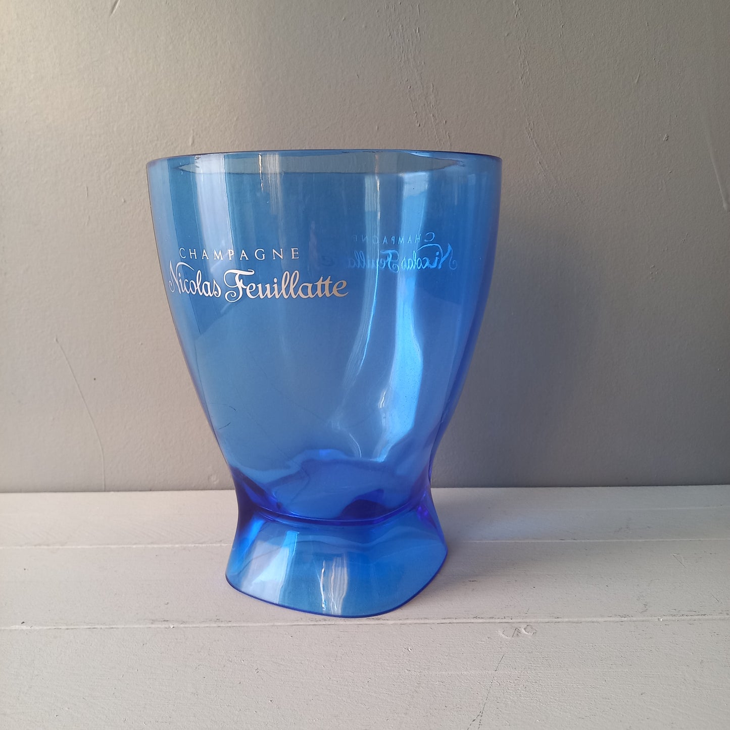 Vintage Nicolas Feuillatte transparent blue champagne bucket made from resin or hardened plastic. Being a vintage item there are of course some scuffs and scratches in the plastic.