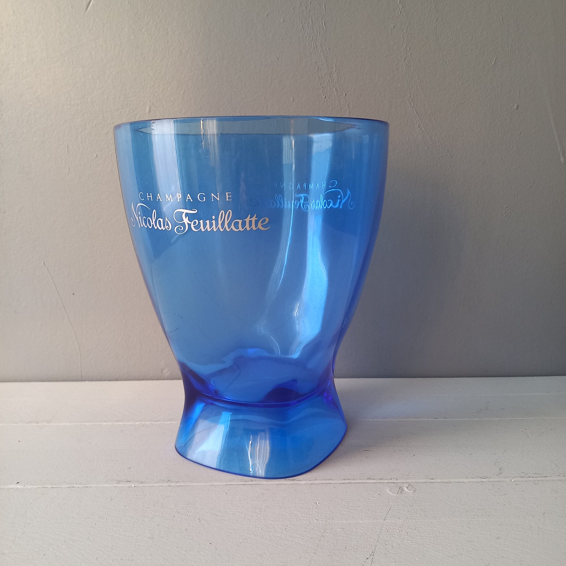 Vintage Nicolas Feuillatte transparent blue champagne bucket made from resin or hardened plastic. Being a vintage item there are of course some scuffs and scratches in the plastic.