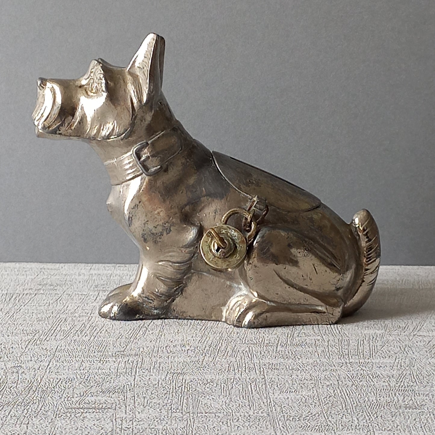 A fabulous French art deco metal terrier dog money box/coin storage box complete with a little padlock and key which still work. 

This unique piece of history was purchased in south west France and we can only imagine who once owned it and what they might have saved their coins to buy.