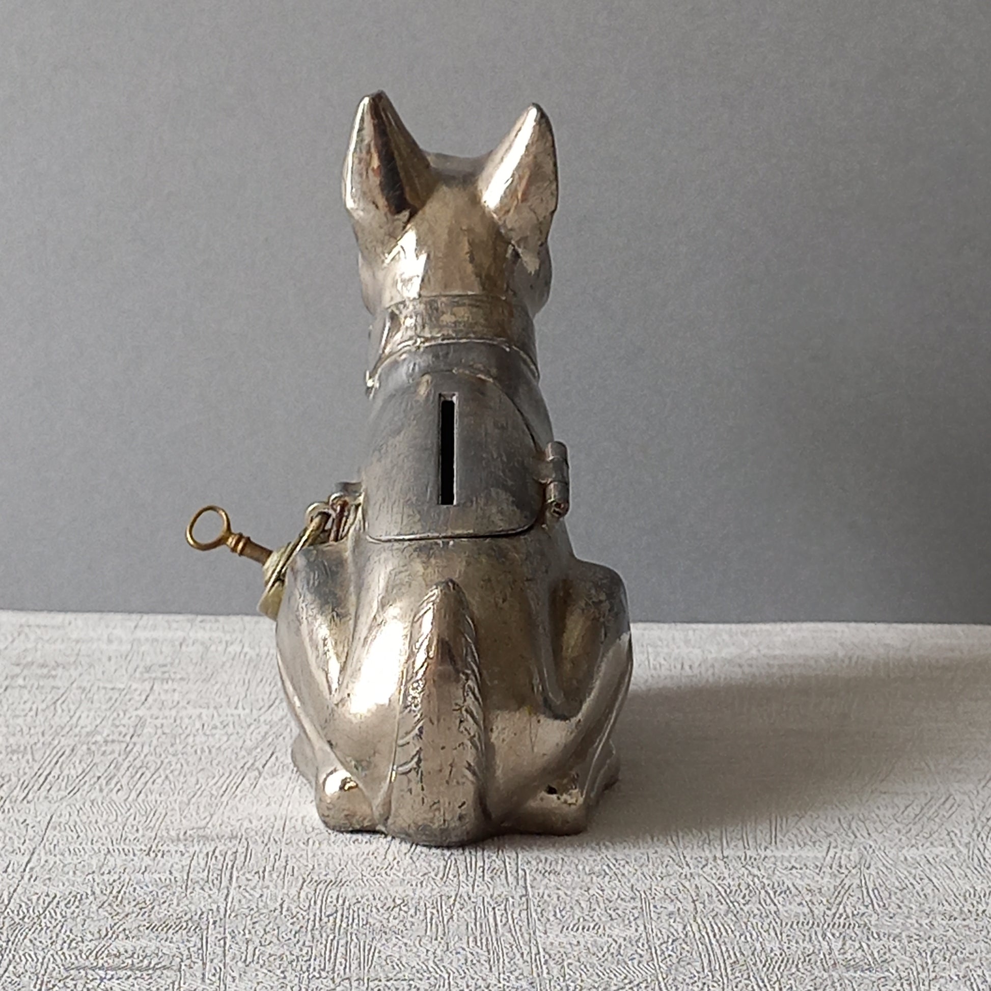 A fabulous French art deco metal terrier dog money box/coin storage box complete with a little padlock and key which still work. 

This unique piece of history was purchased in south west France and we can only imagine who once owned it and what they might have saved their coins to buy.