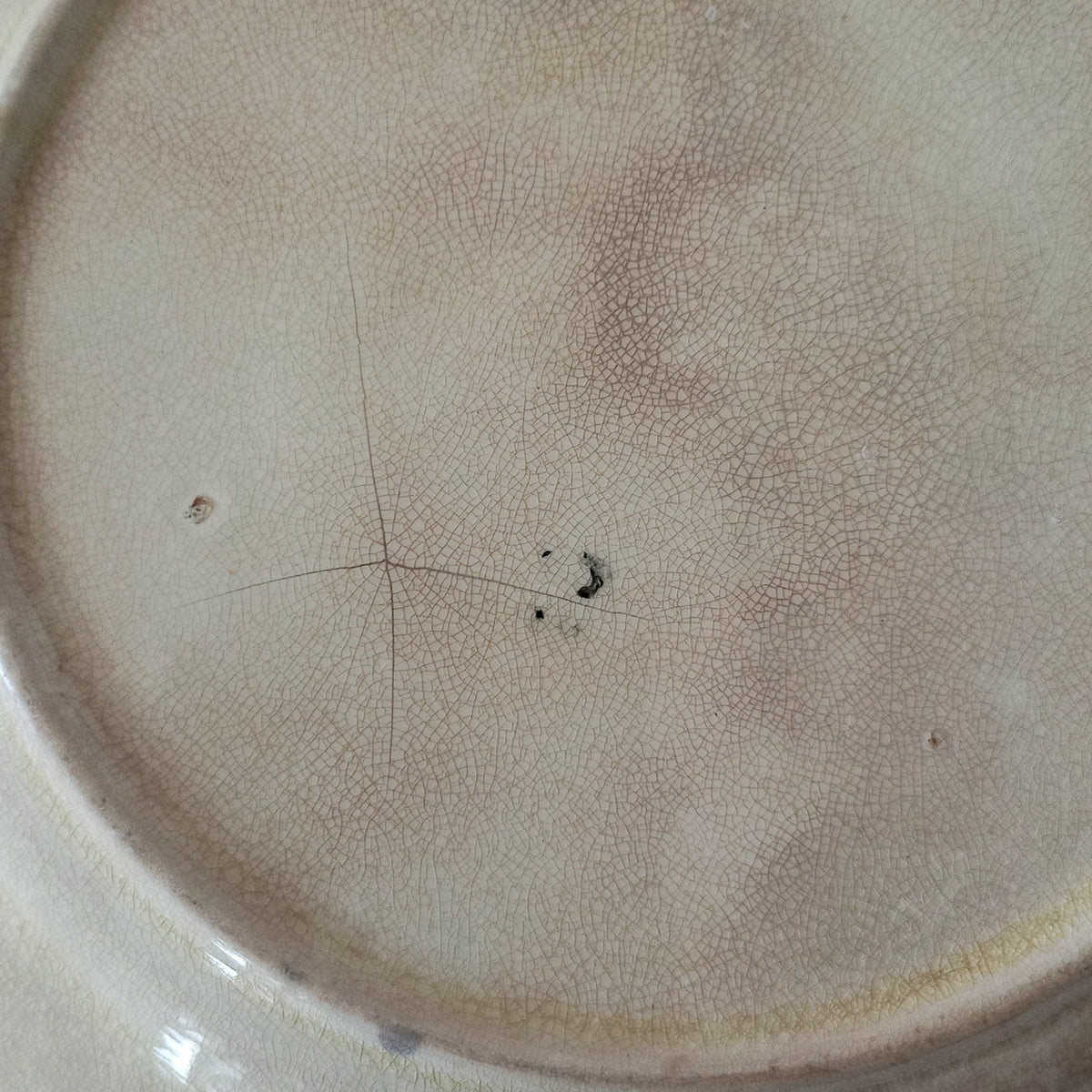 Close-up of a ceramic plate with a textured surface and imperfections.