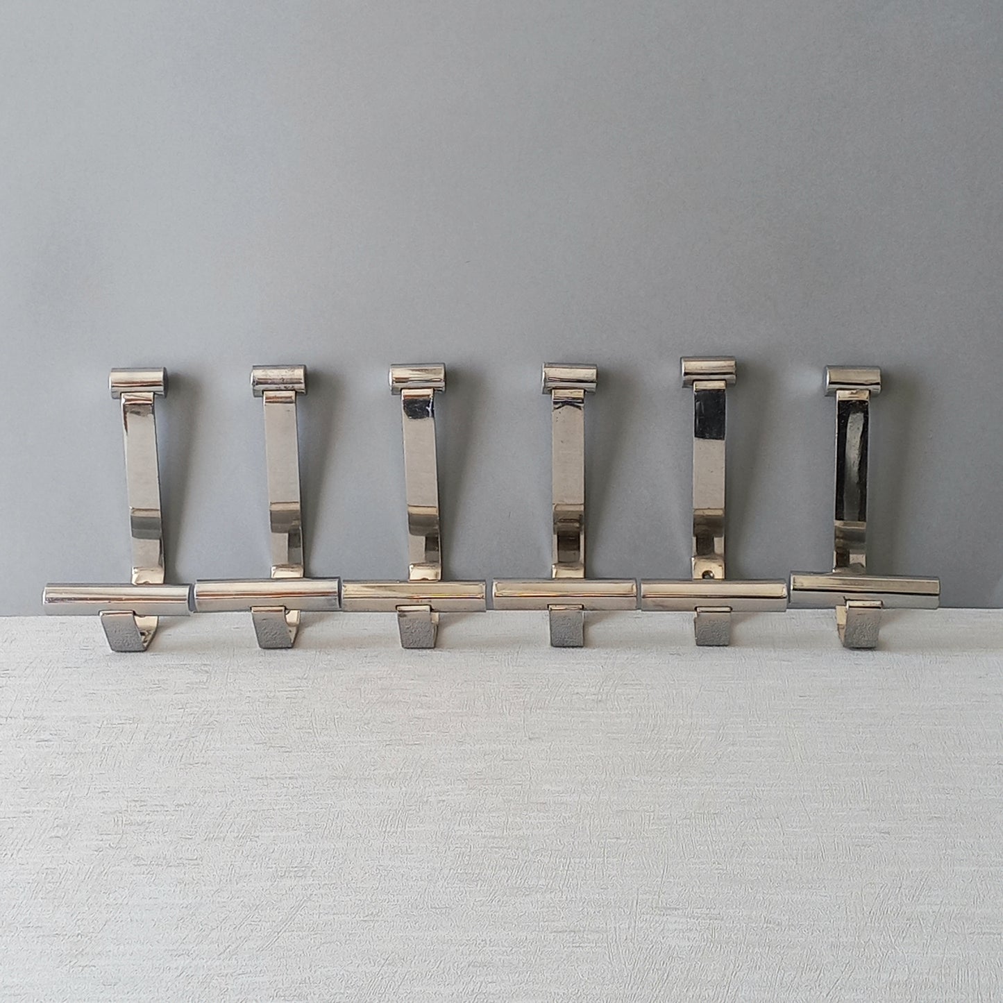 Set of 6 French vintage mid-century coat and hat hooks made from polished metal that can be simply fitted to your wall using the mounting holes.