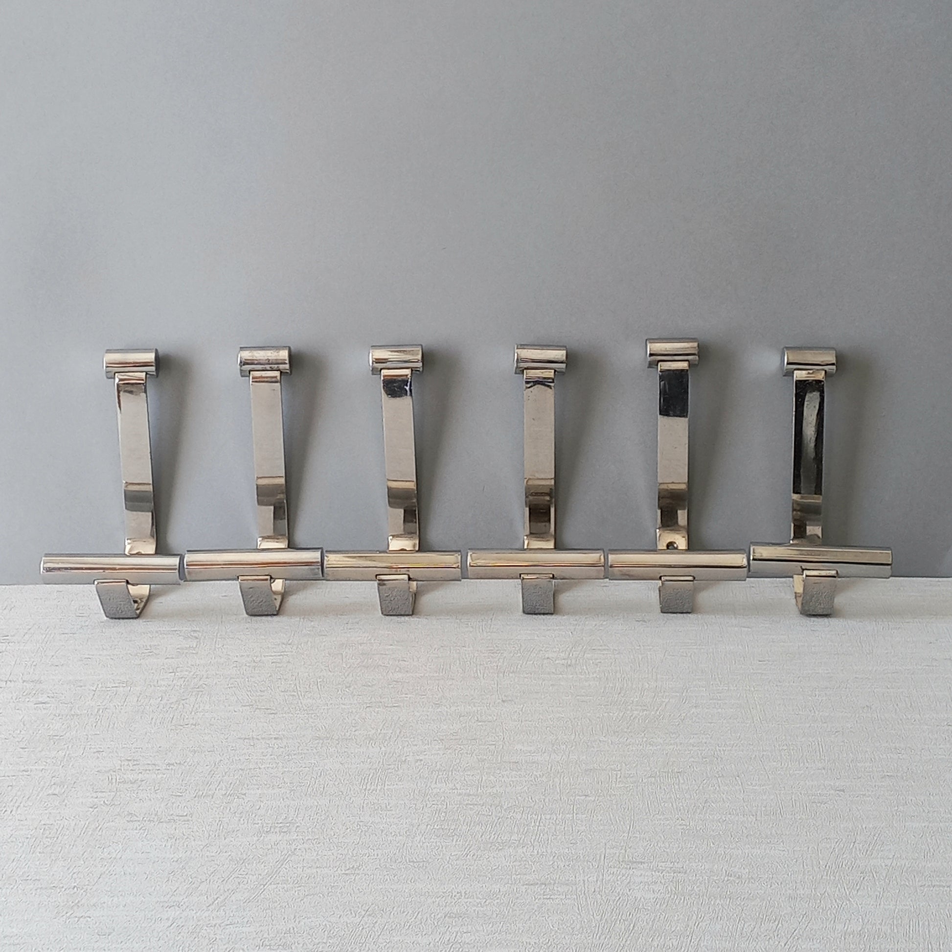 Set of 6 French vintage mid-century coat and hat hooks made from polished metal that can be simply fitted to your wall using the mounting holes.