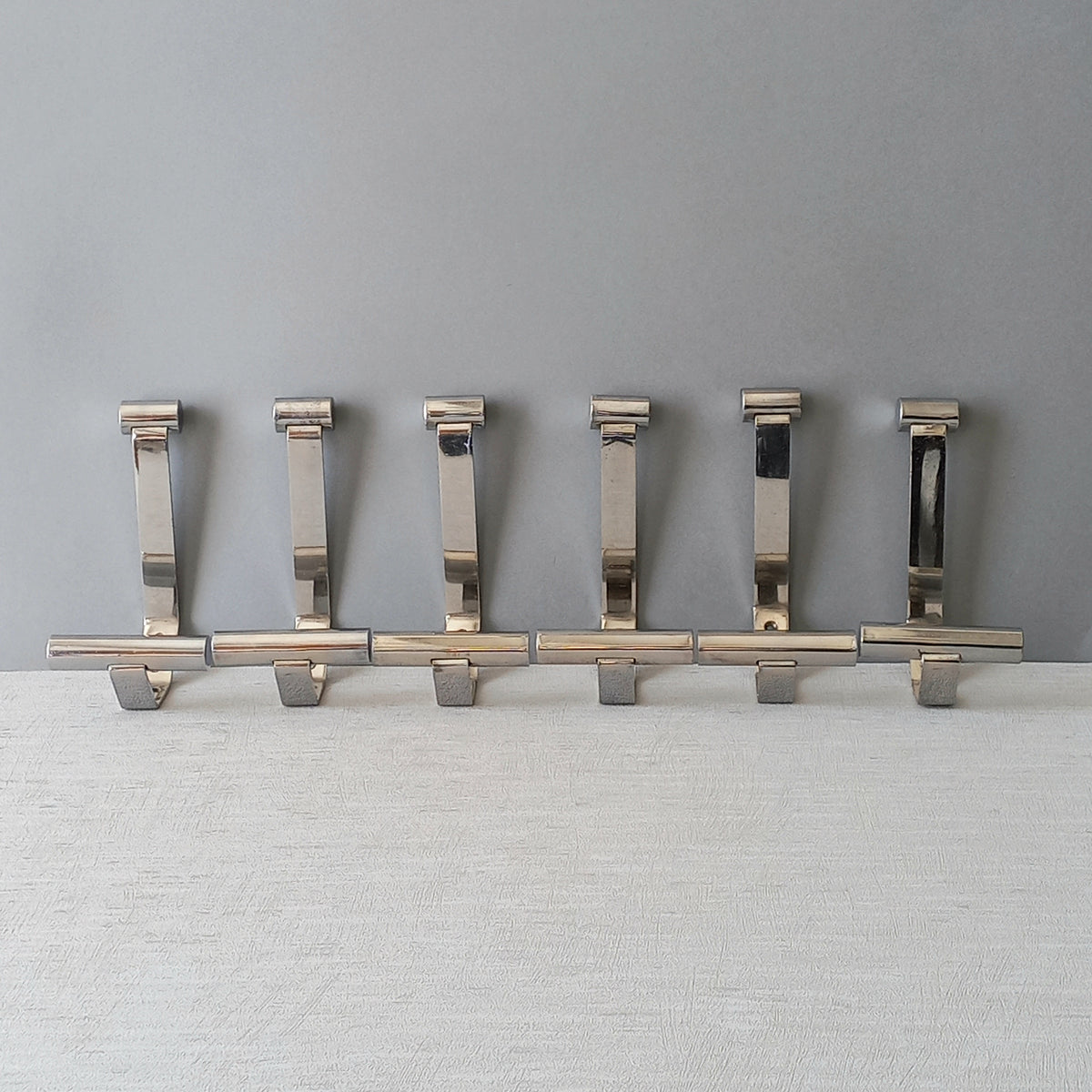 Set of 6 French vintage mid-century coat and hat hooks made from polished metal that can be simply fitted to your wall using the mounting holes.