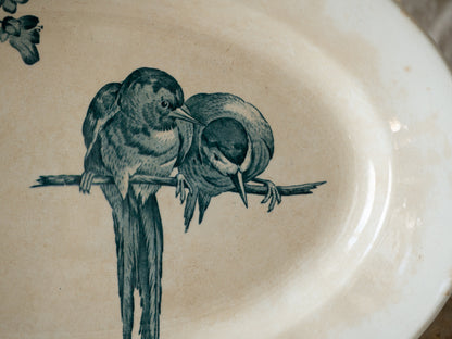 An absolutely stunning large French antique oval ironstone serving plate in a delightful time-worn creamy white with blue transferware pattern depicting two cute birds and flowers. 
