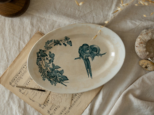 An absolutely stunning large French antique oval ironstone serving plate in a delightful time-worn creamy white with blue transferware pattern depicting two cute birds and flowers. 