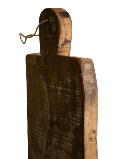 A large vintage wooden chopping board from south west France, shaped by years of use and hand-worn edges. Its rough texture and deep patina tell the story of daily bread, shared meals, and time well lived.
