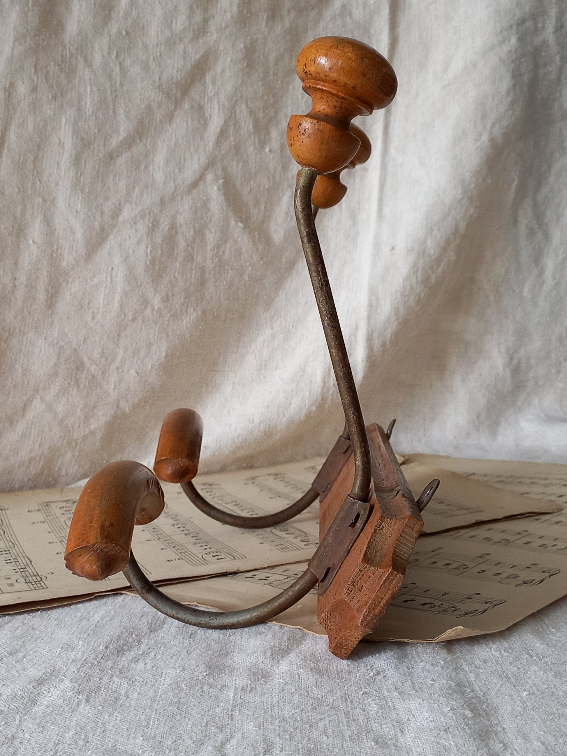 French vintage coat and hat rack with 2 metal hooks, each hook having wooden pegs for a hat and a coat.
