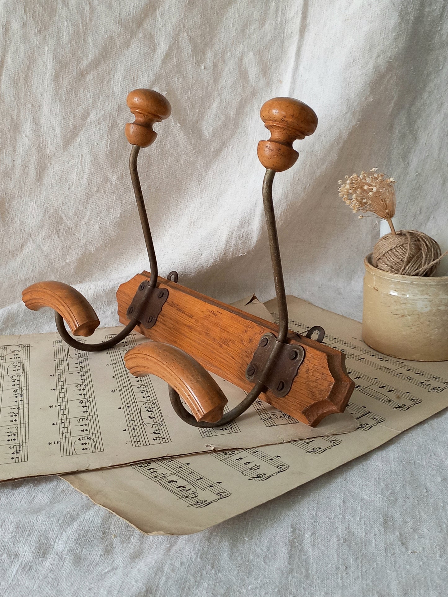 Wooden coat rack on sheet music with a white fabric background
