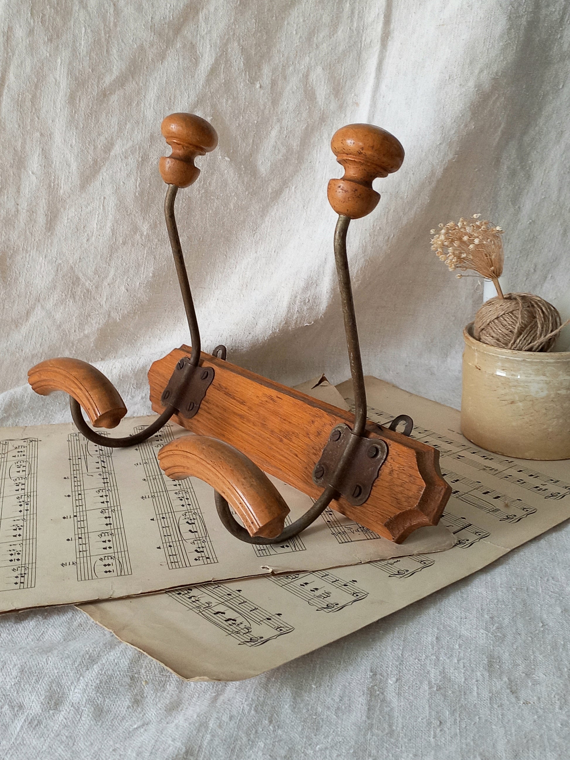 Wooden coat rack on sheet music with a white fabric background