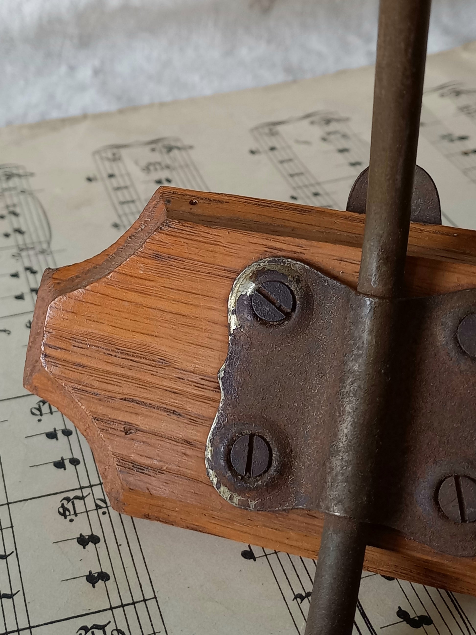 Close-up of a French vintage coat and hat rack with 2 metal hooks, each hook having wooden pegs for a hat and a coat.