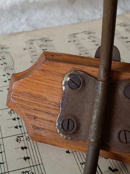 Close-up of a French vintage coat and hat rack with 2 metal hooks, each hook having wooden pegs for a hat and a coat.