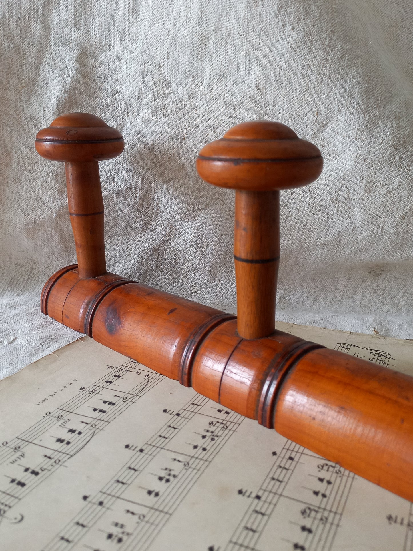 Close-up of French Antique Faux Bamboo Coat Rack with Four Pegs in rustic setting.