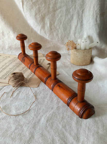 French Antique Faux Bamboo Coat Rack with Four Pegs in rustic setting.