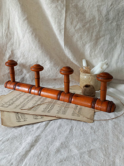 French Antique Faux Bamboo Coat Rack with Four Pegs in rustic setting.