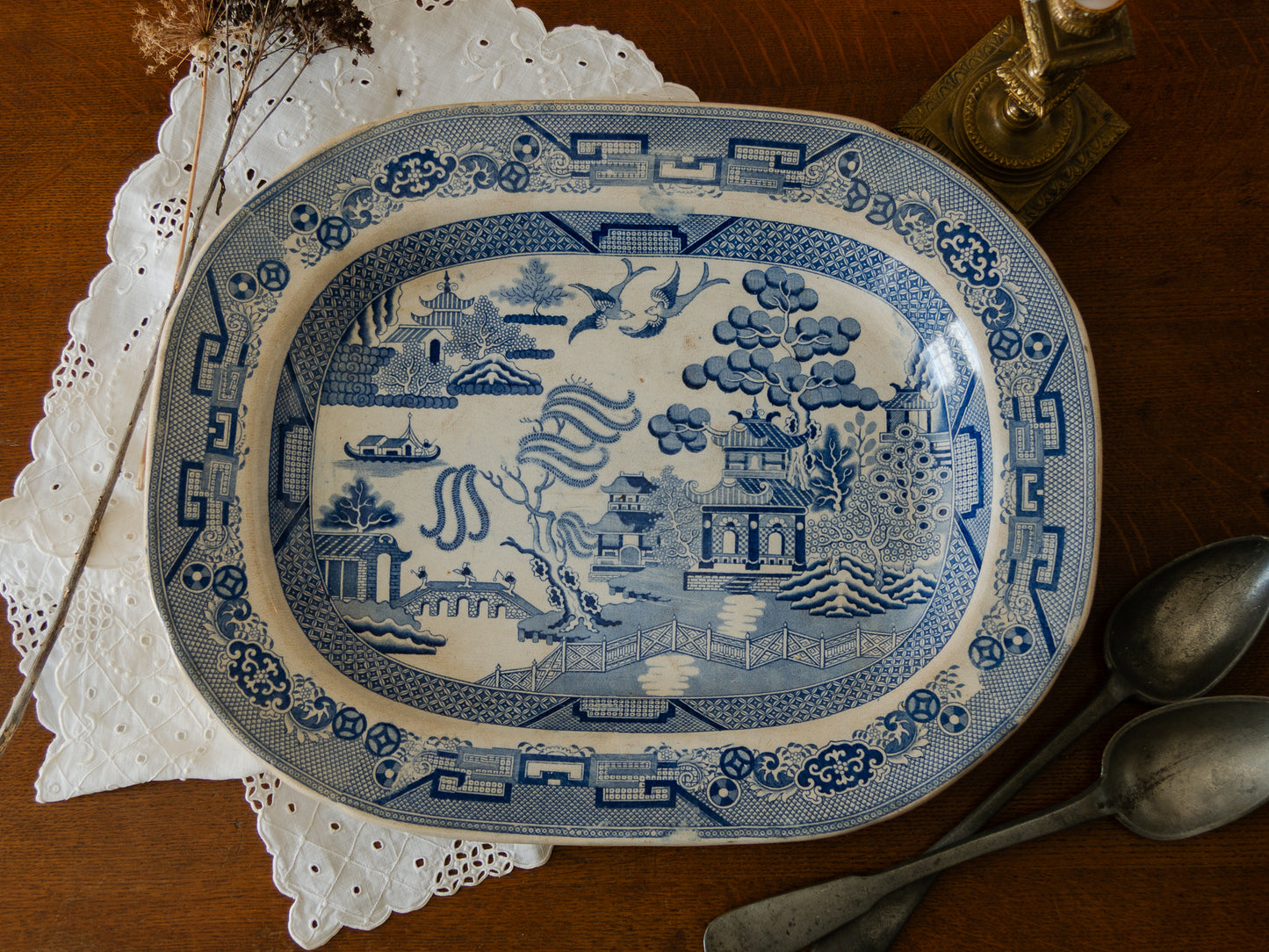 Blue and white decorative plate with landscape design on a wooden surface.