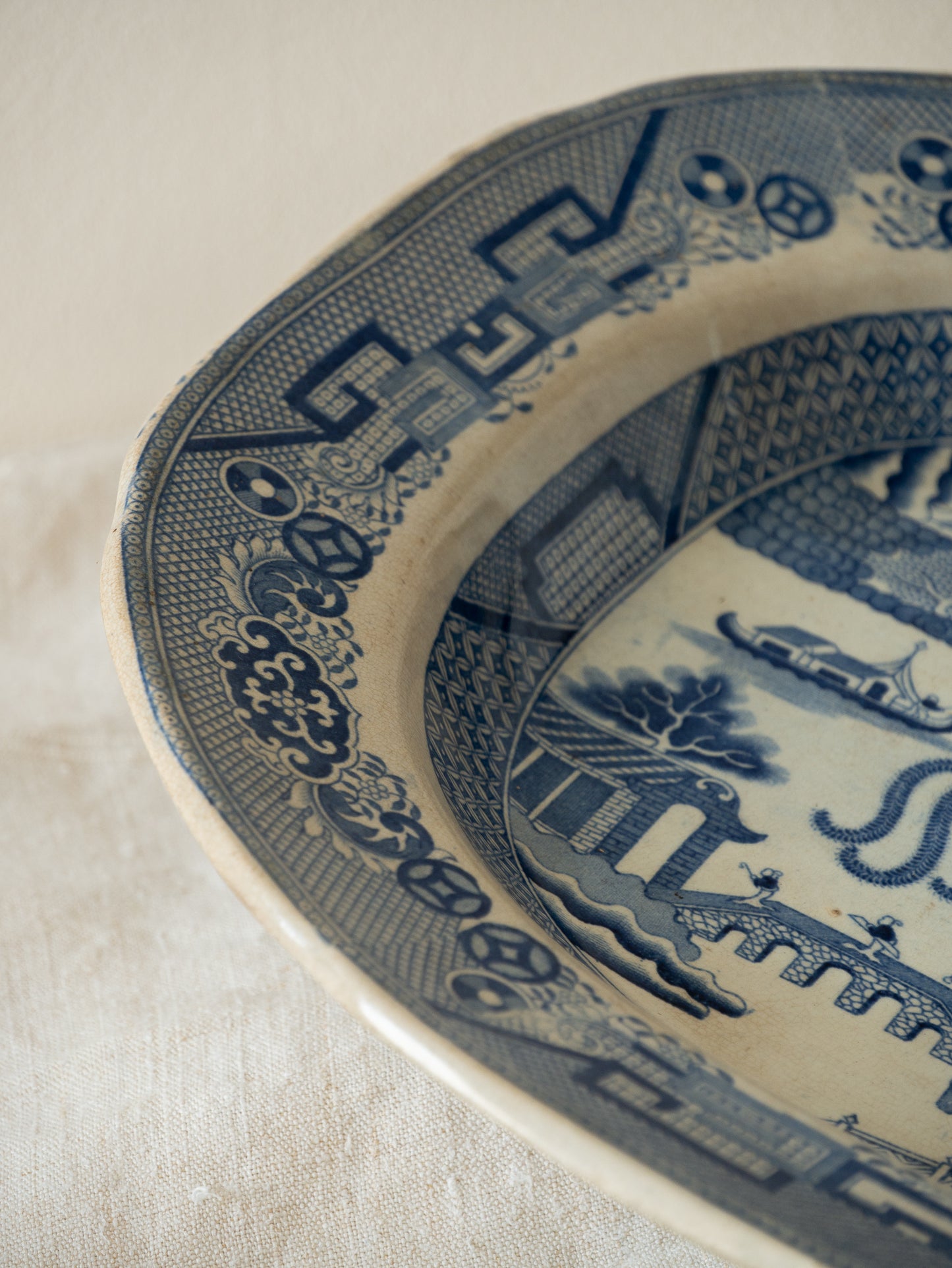 Close-up of a blue and white ceramic plate with intricate patterns on a beige background