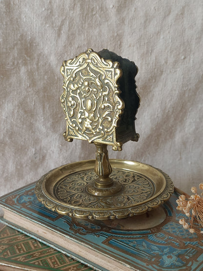 French antique  brass matchbox holder in a decorative setting.