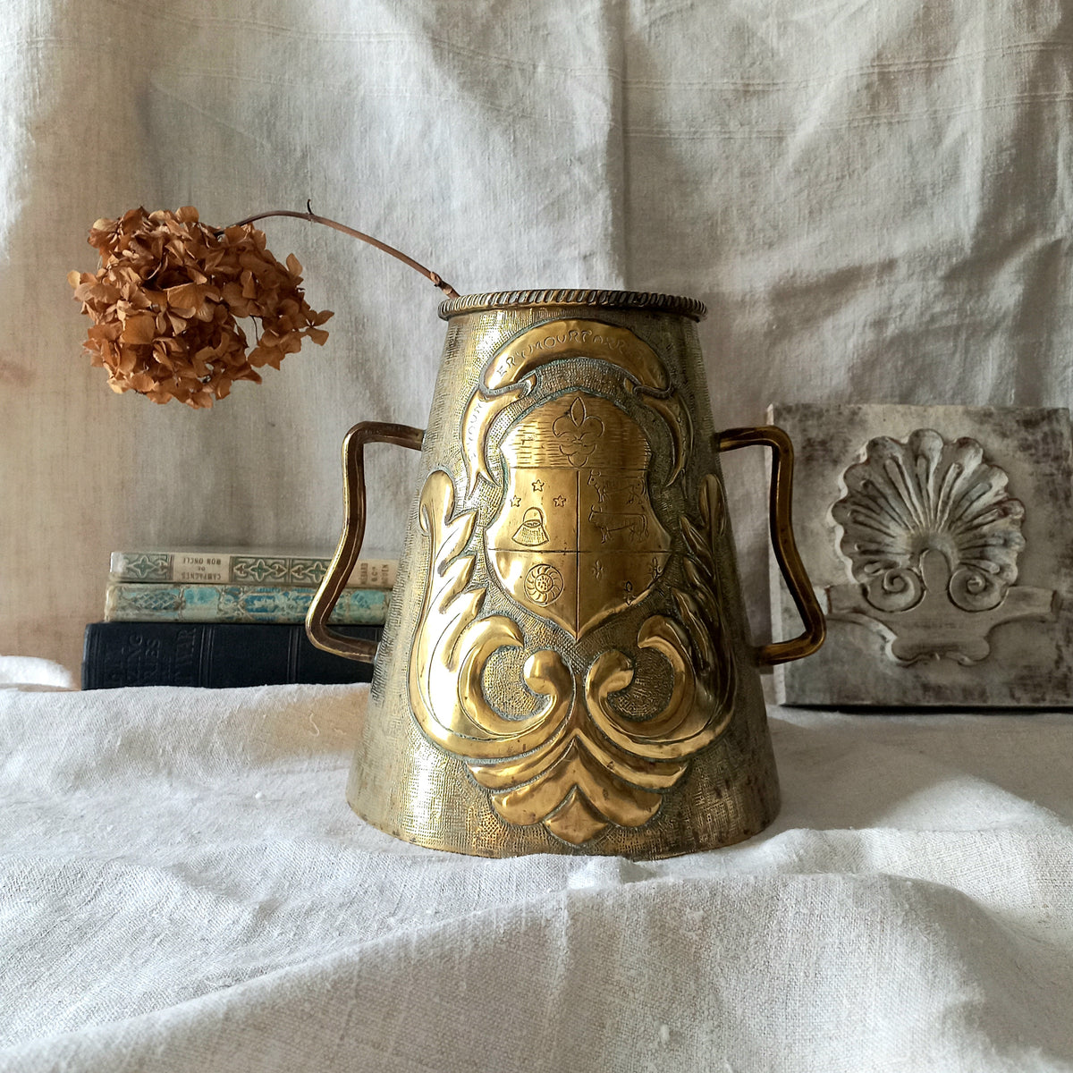 A decorative vintage/antique brass vase with a coat of arms - an unusual piece of brass ware likely a tourist piece inspired by old fountains that were often decorated with a family, commune or regional coat of arms. These days it could have many uses including stand-alone home decor, a decorative vase, or maybe a planter (if considering as a planter the top opening is: 10.7 cm (just over 4'').