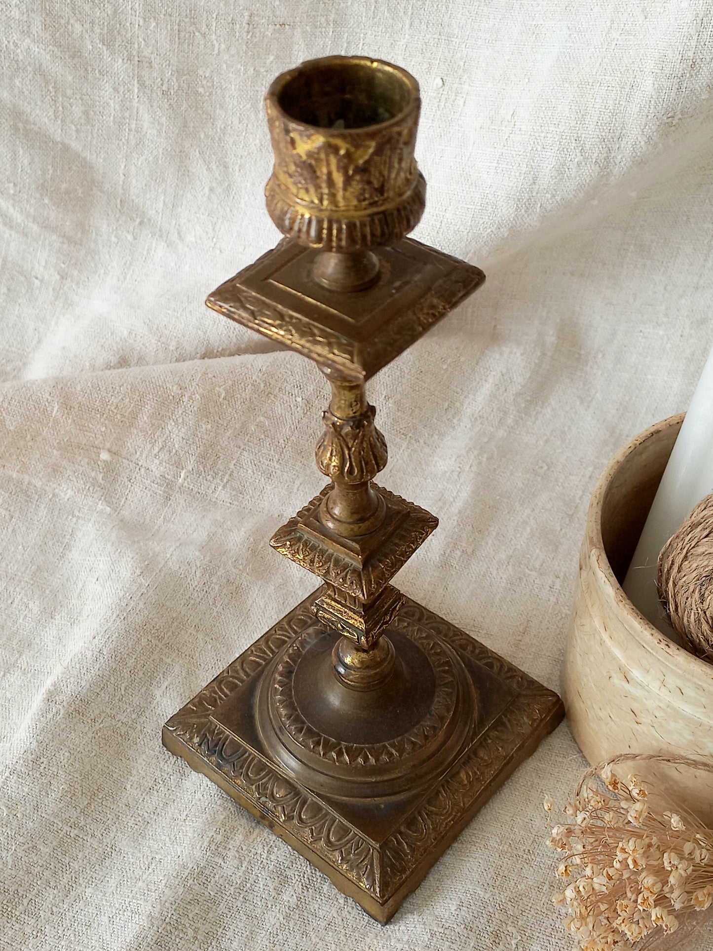 Decorative bronze candlestick on a textured white surface