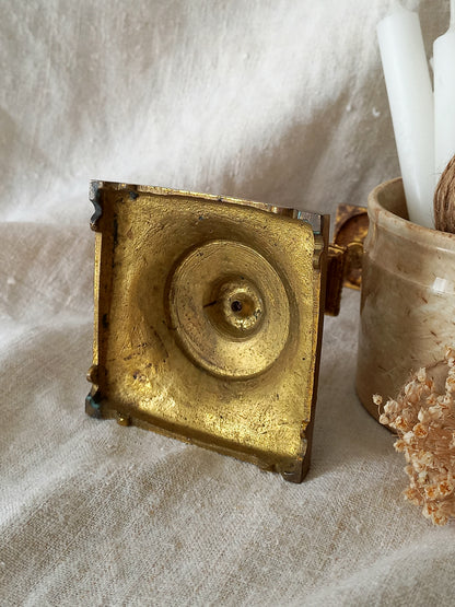 Gold decorative object on a textured surface with a white fabric background
