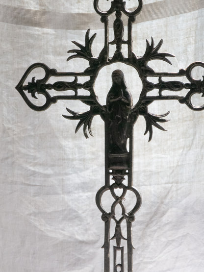 A large French antique crucifix in cast or wrought iron, featuring a figure of the Madonna at its center. Likely once part of a larger architectural structure, this rare piece carries visible signs of age and long exposure to the elements.