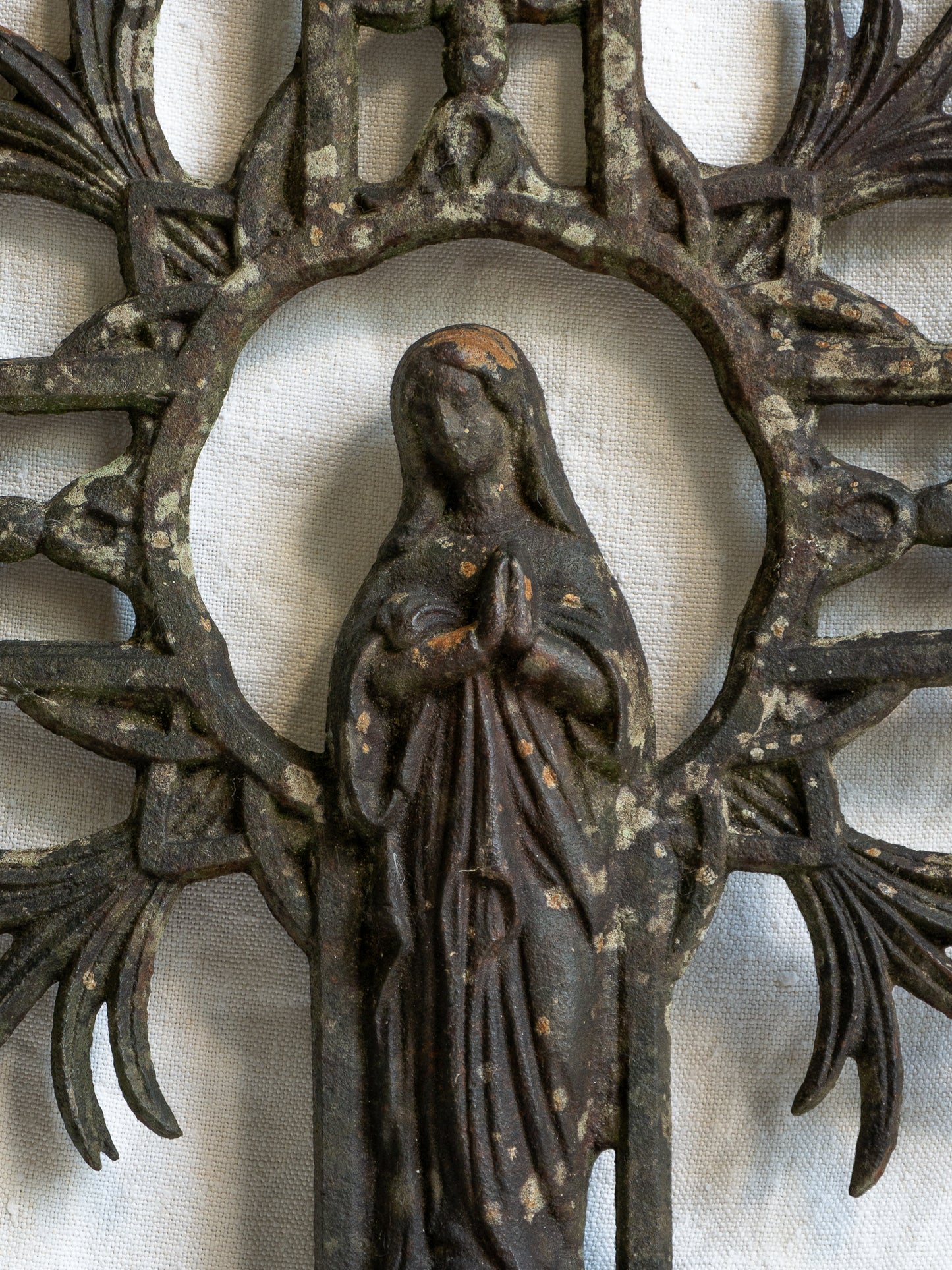 A large French antique crucifix in cast or wrought iron, featuring a figure of the Madonna at its center. Likely once part of a larger architectural structure, this rare piece carries visible signs of age and long exposure to the elements.