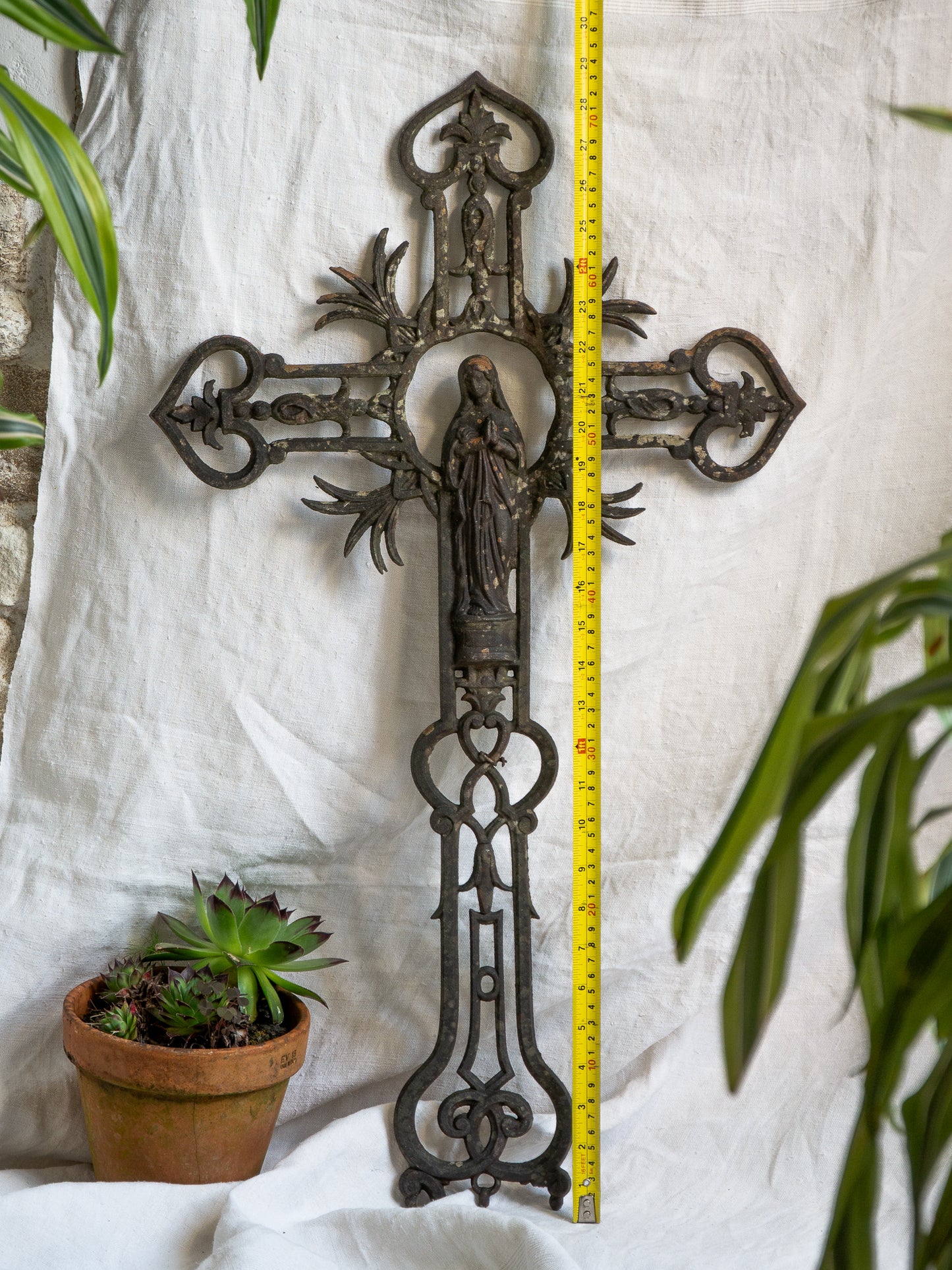 A large French antique crucifix in cast or wrought iron, featuring a figure of the Madonna at its center. Likely once part of a larger architectural structure, this rare piece carries visible signs of age and long exposure to the elements.