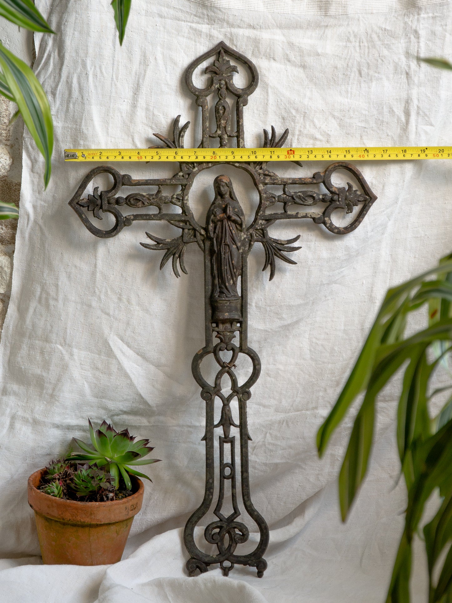 A large French antique crucifix in cast or wrought iron, featuring a figure of the Madonna at its center. Likely once part of a larger architectural structure, this rare piece carries visible signs of age and long exposure to the elements.