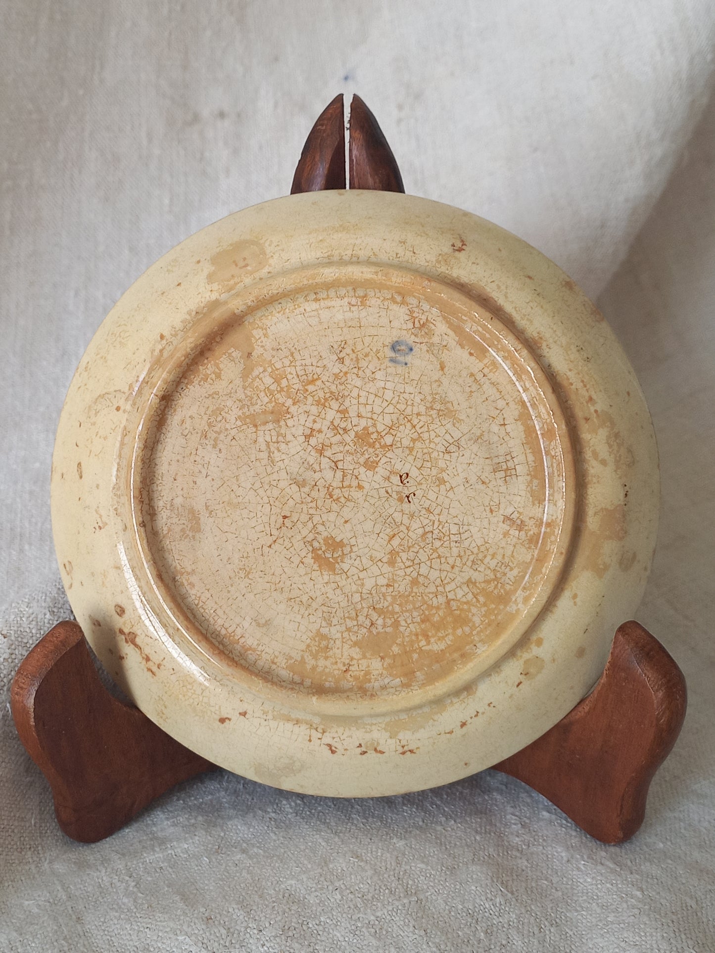 Close-up of the underneath of a ceramic plate with a tea-stained  surface.