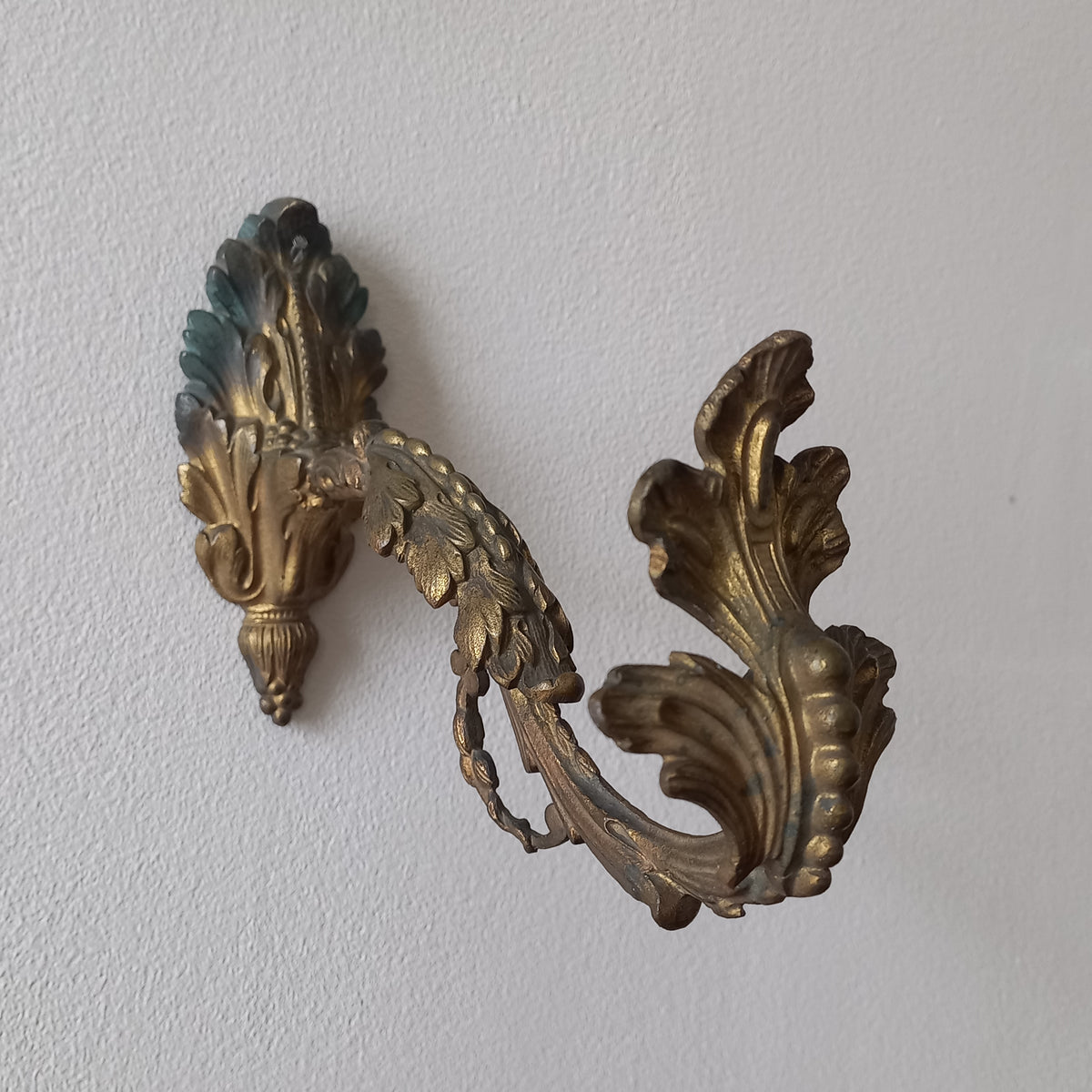 Decorative gold leaf design on a textured white surface