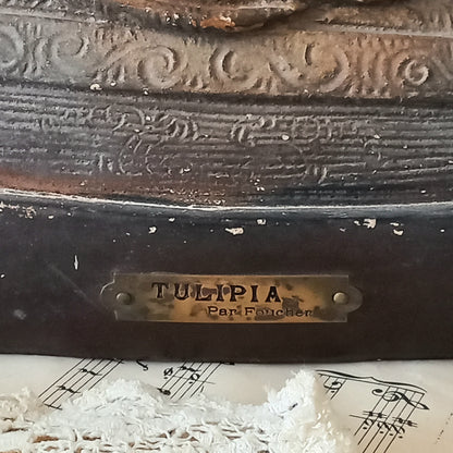 Antique bust of a woman wearing a bonnet on a white fabric background