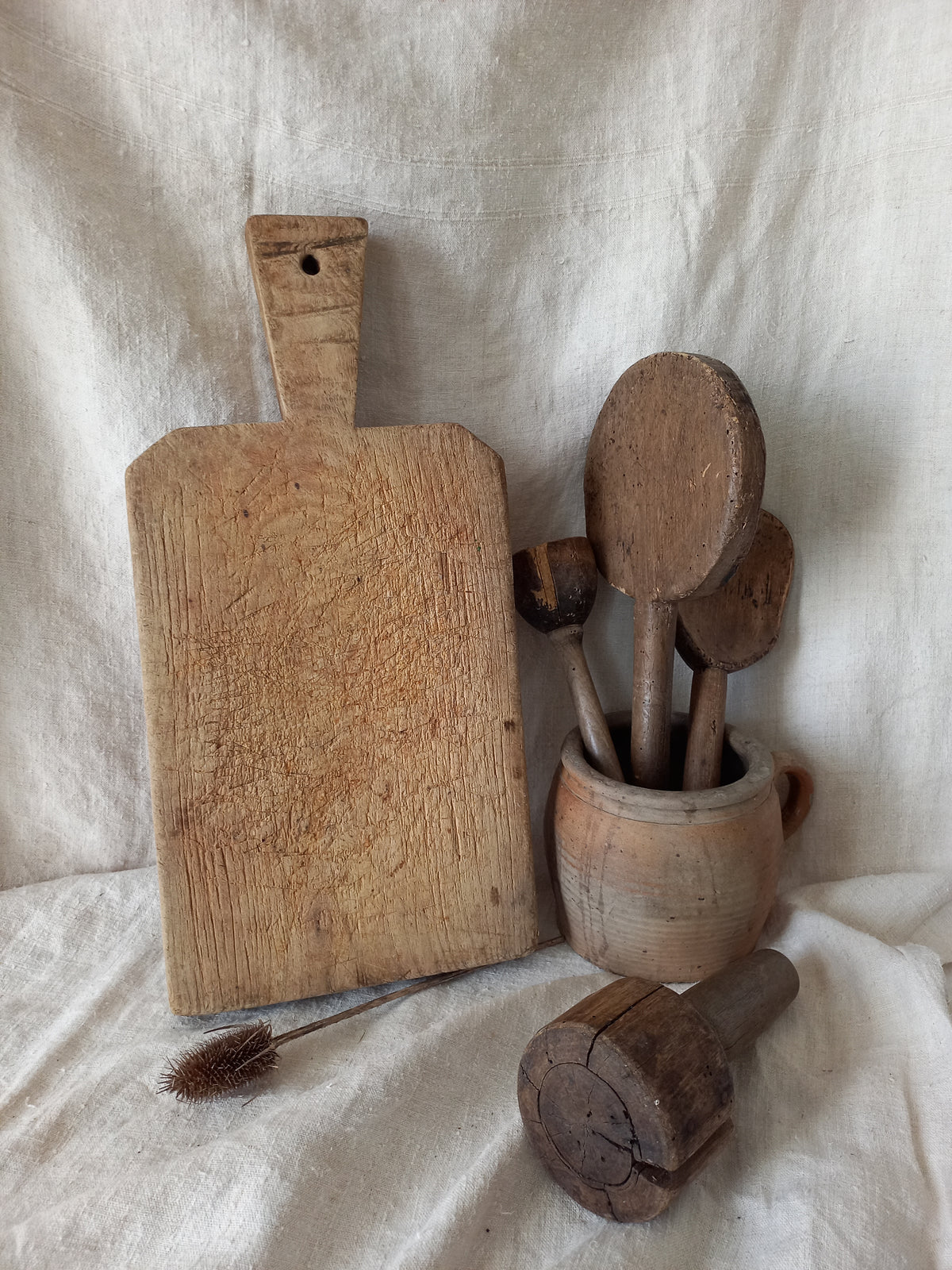Antique French chunky hand-carved wooden cutting board in a rustic setting.