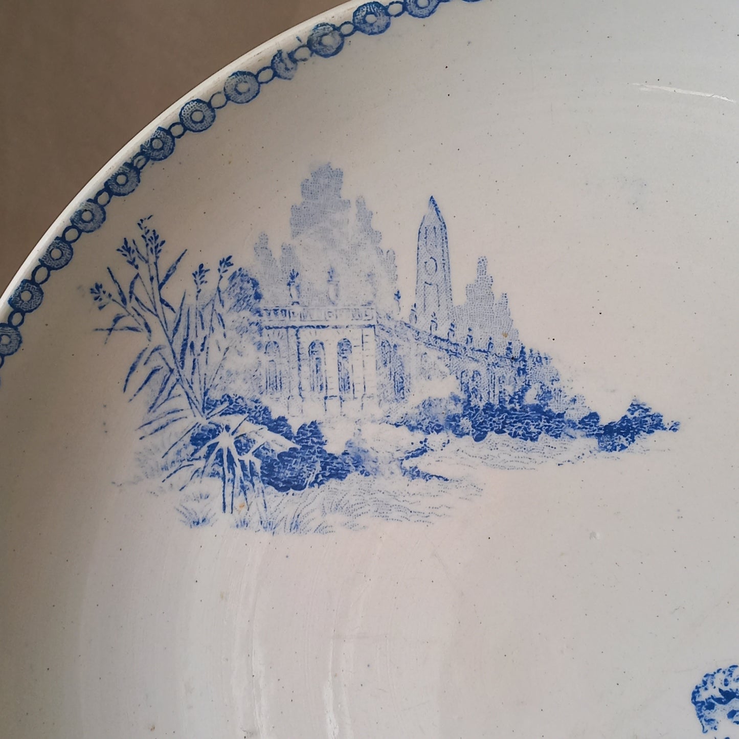 An attractive French antique footed ironstone cake plate with a blue transfer pattern depicting architecture, cherubs, and flowers; a very pretty and delicate pattern.

Original antique ironstone pieces of this age and condition are becoming increasingly difficult to source to this a rare treat to discover.
