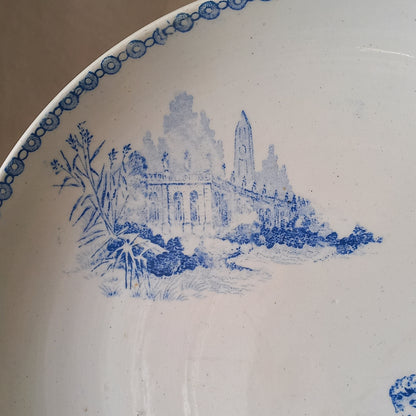 An attractive French antique footed ironstone cake plate with a blue transfer pattern depicting architecture, cherubs, and flowers; a very pretty and delicate pattern.

Original antique ironstone pieces of this age and condition are becoming increasingly difficult to source to this a rare treat to discover.
