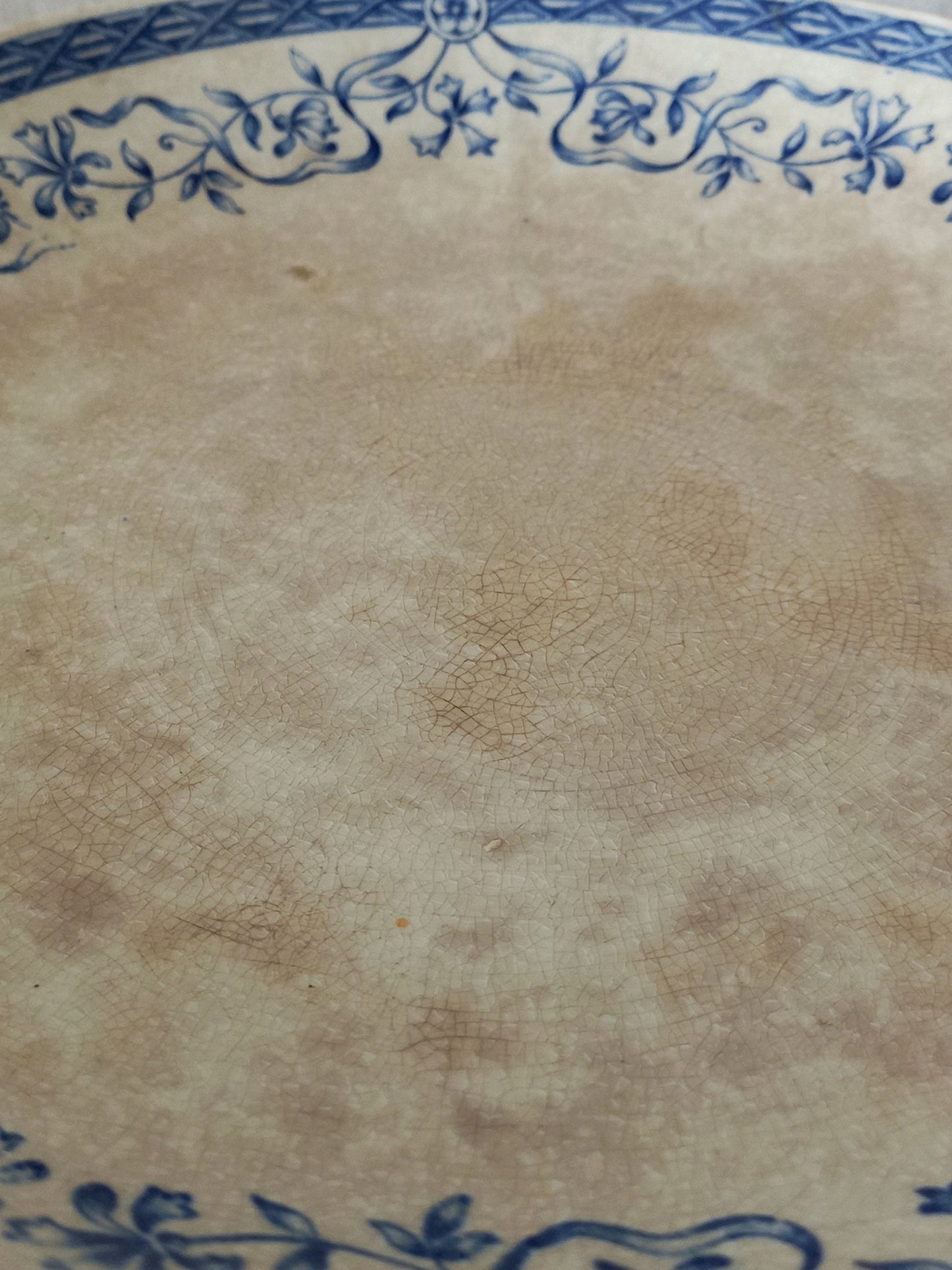 Close-up of a ceramic cake plate with blue floral patterns on a beige background