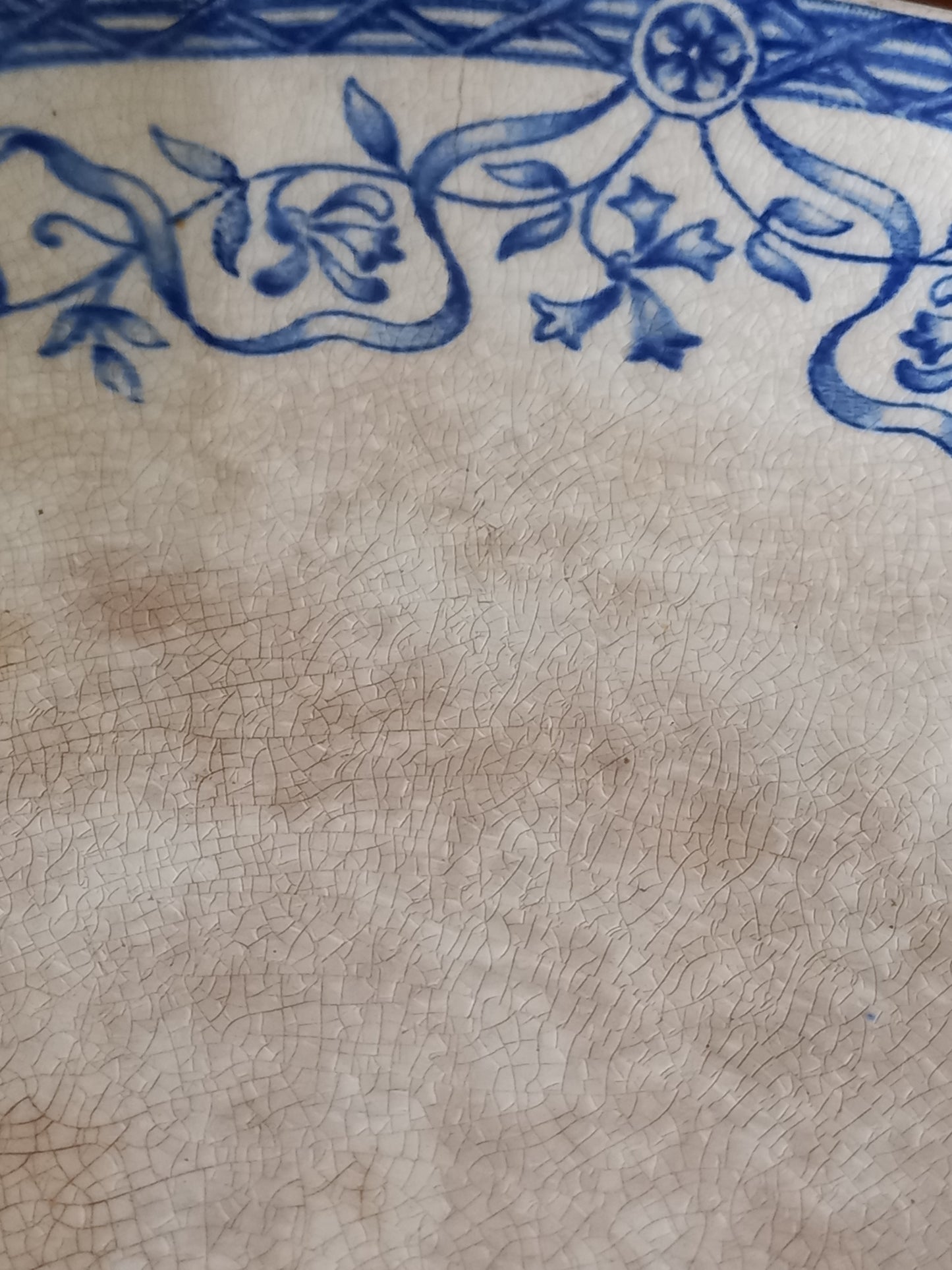 Close-up of a ceramic cake plate with blue floral patterns on a beige background