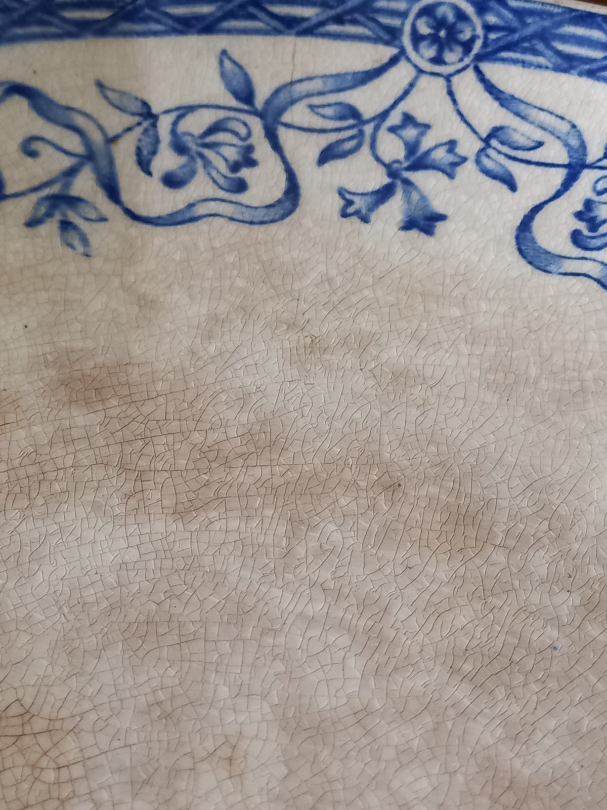 Close-up of a ceramic cake plate with blue floral patterns on a beige background