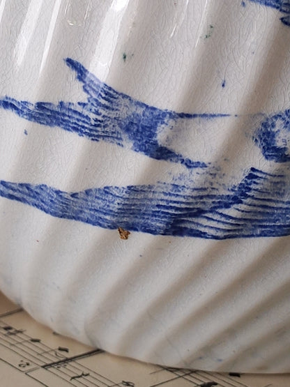 A stunning French antique ironstone wash jug pitcher in white with a gentle blue/violet floral pattern and a bird on the opposite side.